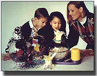 Photo of children and adult with a balloon stuffing machine. BHQ - the most complete collection of balloon info on the web.